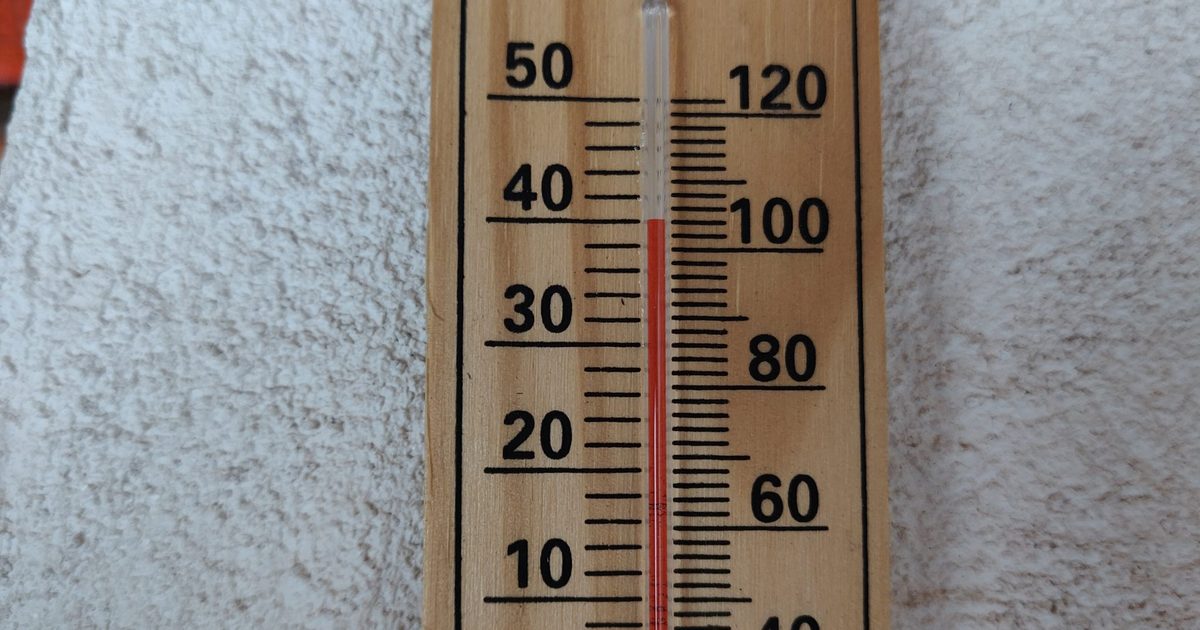 A wooden wall thermometer with Celsius and Fahrenheit scales, its red column standing at about 40 degrees Celsius